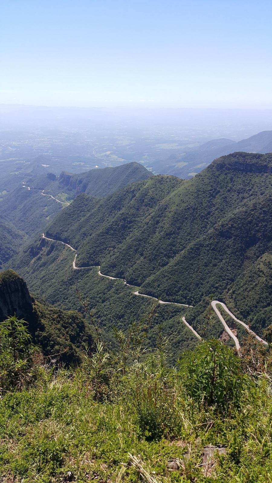 Vista aérea das curvas da estrada da Serra do Rio do Rastro, cercada por mata fechada